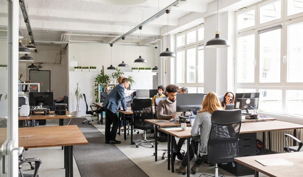 Business people working at desks. Male and female professionals working in modern office space.